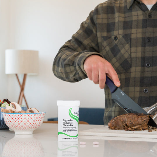 picture of man cutting mean with the bottle in front