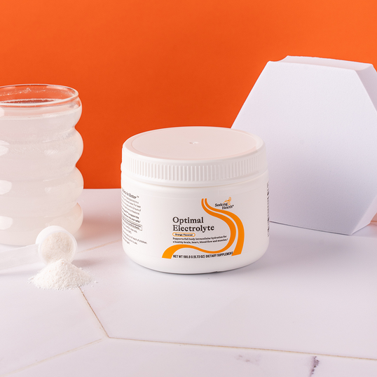 Container of Optimal Electrolyte on a white surface with an orange background