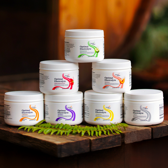 Stack of Optimal Electrolyte containers on a wooden surface with a blurred background