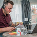 image of man working at desk with headset on | AB-2