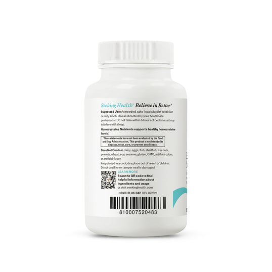 A white bottle of Seeking Healths Believe in Bene product shown from the back, featuring a white cap, a white background, and a detailed black text label with a barcode and teal accents.